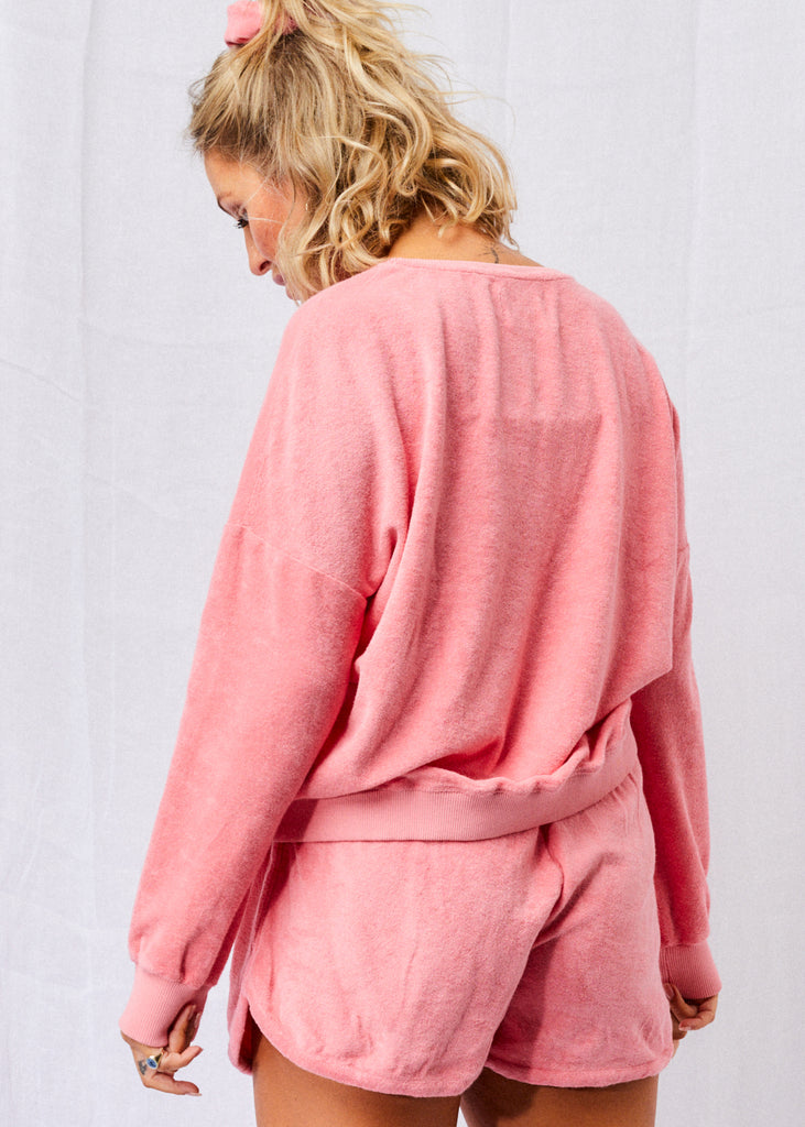 Frottee Sweatshirt aus nachhaltiger Biobaumwolle an mid-size Model in Wassermelonen Pink, kombiniert mit Frotteshorts und Scrunchie